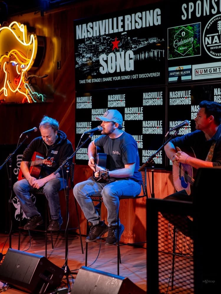 Three songwriters performing in the round on the Nashville Rising Song stage